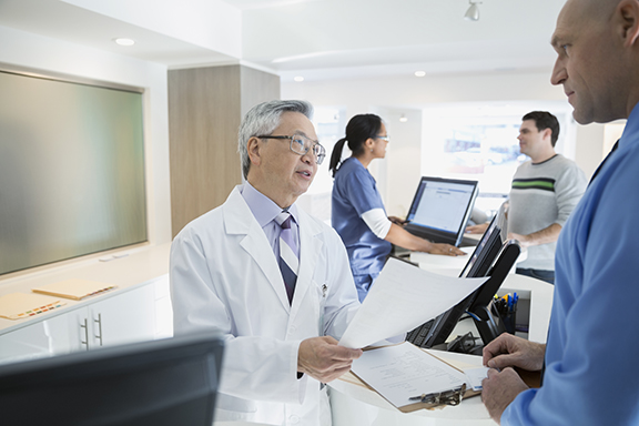 Doctor discussing paperwork with patient in clinic