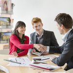 Real estate agent discussing property documents to his clients