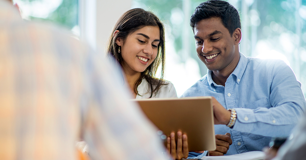 co-workers reviewing tablet as they're starting a business