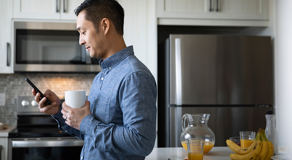 Man using mobile phone in kitchen